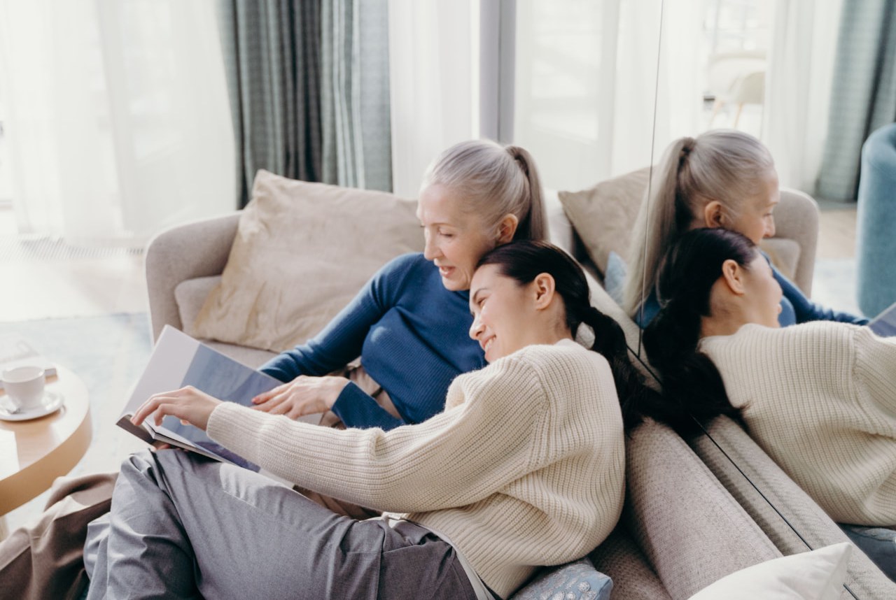 Adult daughter sharing a warm moment with her older mother at home.